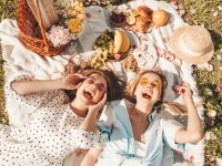 two-young-beautiful-smiling-female-in-trendy-summer-sundress-and-hats-carefree-women-making-picnic-outside