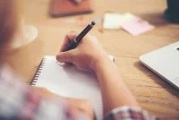 Young hipster woman writing and work in workplace. &copy;Freepik